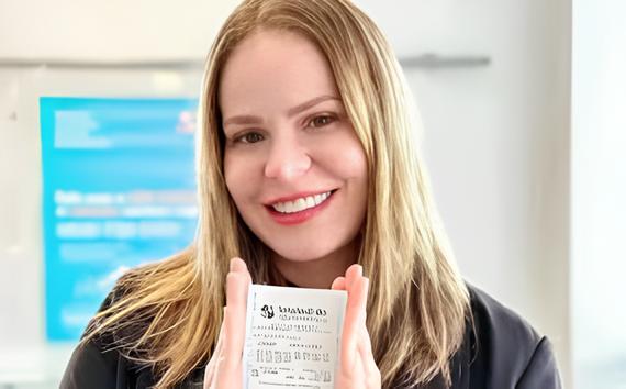 Paulinha Leite segura vários bilhetes de loteria.