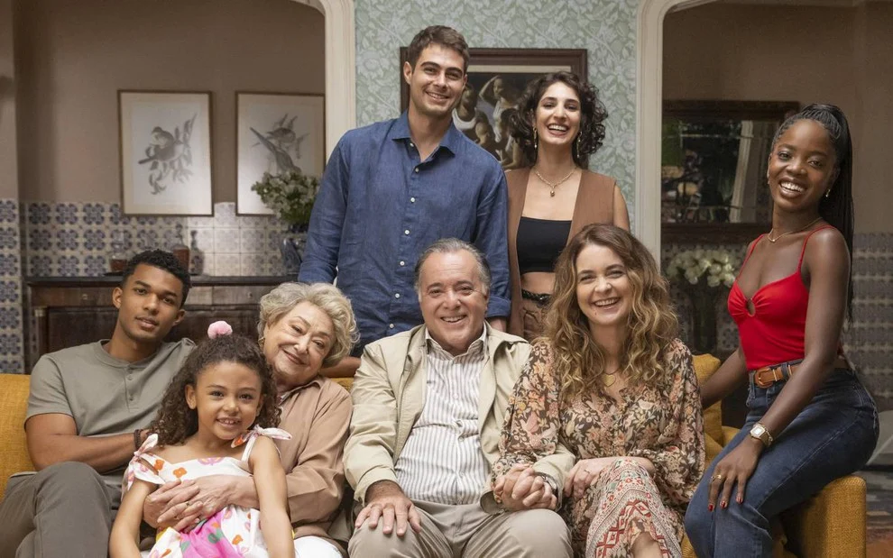 Família Boaz reunida e sorrindo com a babá em Dona de Mim.”